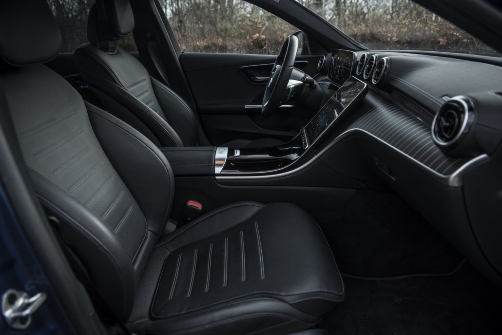 Der vordere Teil des Innenraums einer neuen Mercedes C-Klasse mit Sitzen, Displays und Lenkrad.