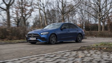 Eine blaue Mercedes C-Klasse Limousine fährt auf einem Parkplatz.