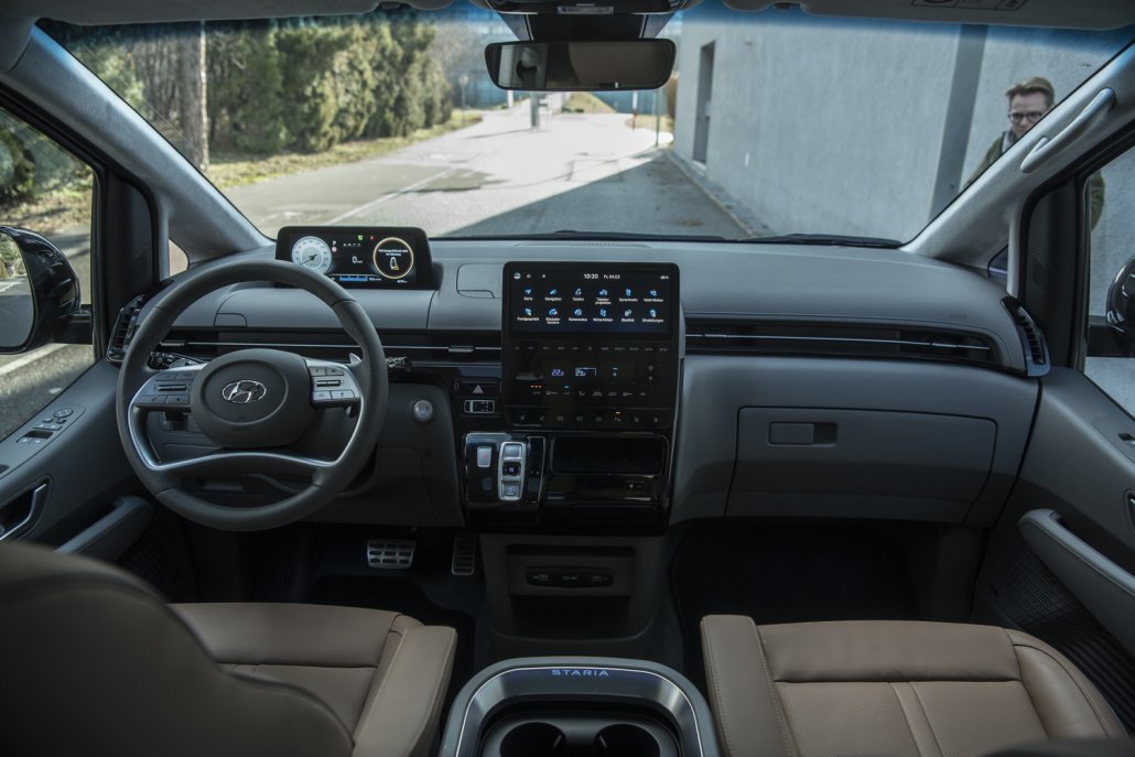 Das Cockpit des Hyundai Staria mit einem vierspeichigen Lenkrad, über dem sich digitale Armaturen befinden, sowie einem Touchscreen auf der Mittelkonsole.