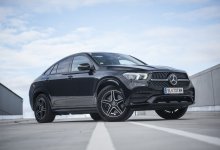 Ein schwarzer Mercedes GLE 350 de steht auf Asphalt vor blauem Himmel.