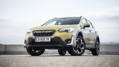 Ein dunkelgelber Subaru XV e-Boxer steht auf einem Parkdeck an einem bewölkten Tag.