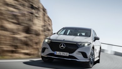 Ein grauer Mercedes EQS SUV fährt an einer Felswand vorbei