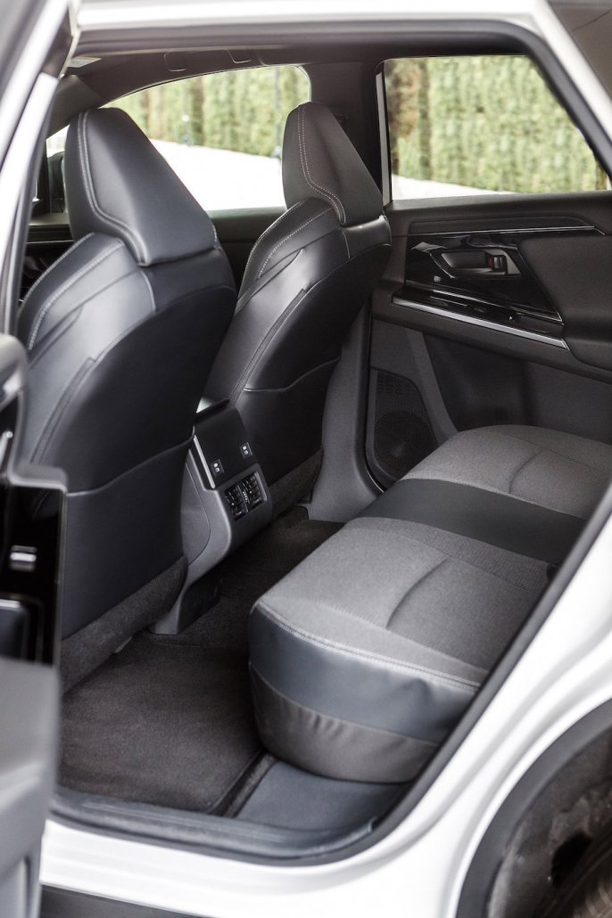 Die linke, hintere Tür eines Toyota bZ4X ist geöffnet und gewährt einen Einblick auf die mit dunklem Stoff überzogene Sitzreihe.