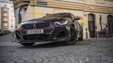 Ein BMW 2er Coupé in der Farbe Thundernight metallic steht vor einer Garageneinfahrt voller Graffiti