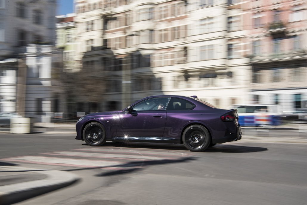 Ein violettes BMW 2er Coupé fährt durch die Stadt