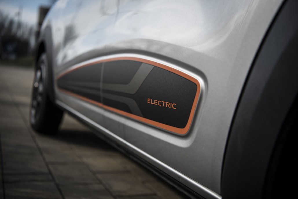 Detailaufnahme der orangenen Akzente an den Türen eines silbernen Dacia Spring Electrics.