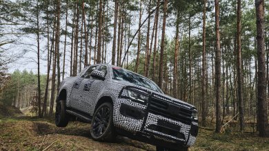 Ein VW Amarok in Tarnfolie fährt offroad durch den Wald