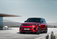 Ein roter Range Rover Sport steht vor einem modernen Haus