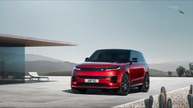Ein roter Range Rover Sport steht vor einem modernen Haus