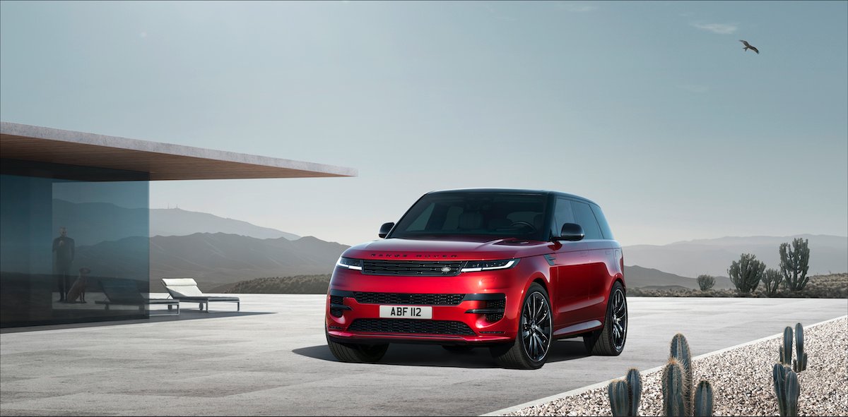 Ein roter Range Rover Sport steht vor einem modernen Haus