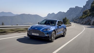 Ein blauer Aston Martin DBX 707 fährt auf einer Landstraße