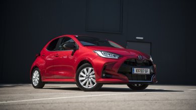 Ein roter Mazda 2 steht vor einer dunklen Wand