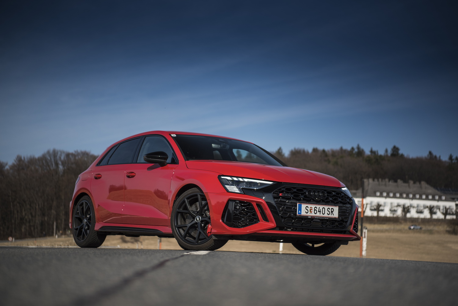 Ein roter Audi RS 3 steht quer auf einer Landstraße