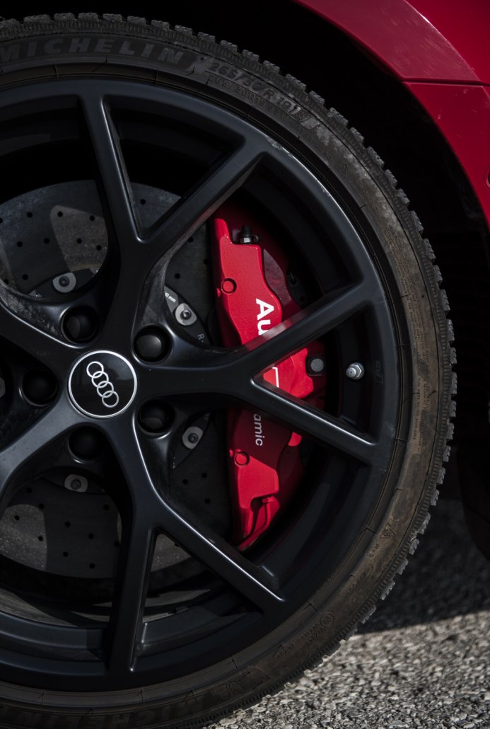 Vorderrad eines roten Audi RS 3 mit schwarzer Felge und rotem Bremssattel