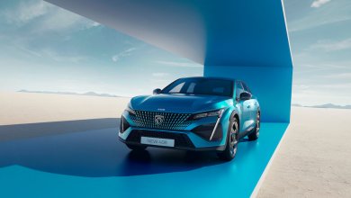 Ein blauer Peugeot 408 steht auf einer blauen Konstruktion umgeben von Sand