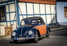 Ein Hebmüller Käfer fährt durch ein Dorf