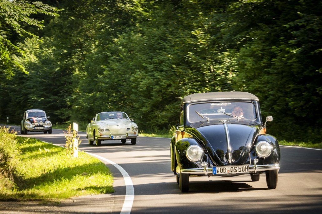 Ein Rallye-Käfer, Kharmann Ghia Cabrio und Hebmüller Käfer fahren im Konvio über eine Landstraße