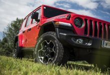 Ein roter Jeep Wrangler steht auf einer Wiese