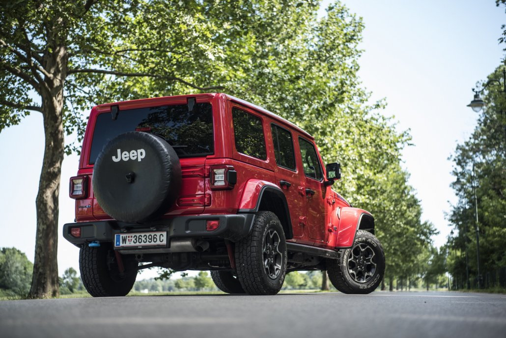 Ein roter Jeep Wrangler Hybrid steht auf einer Allee