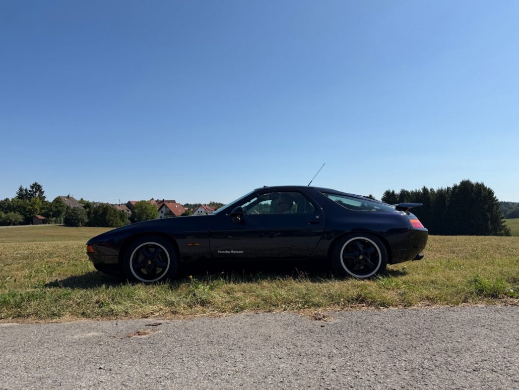 Dunkler Porsche 928 auf einer Wiese