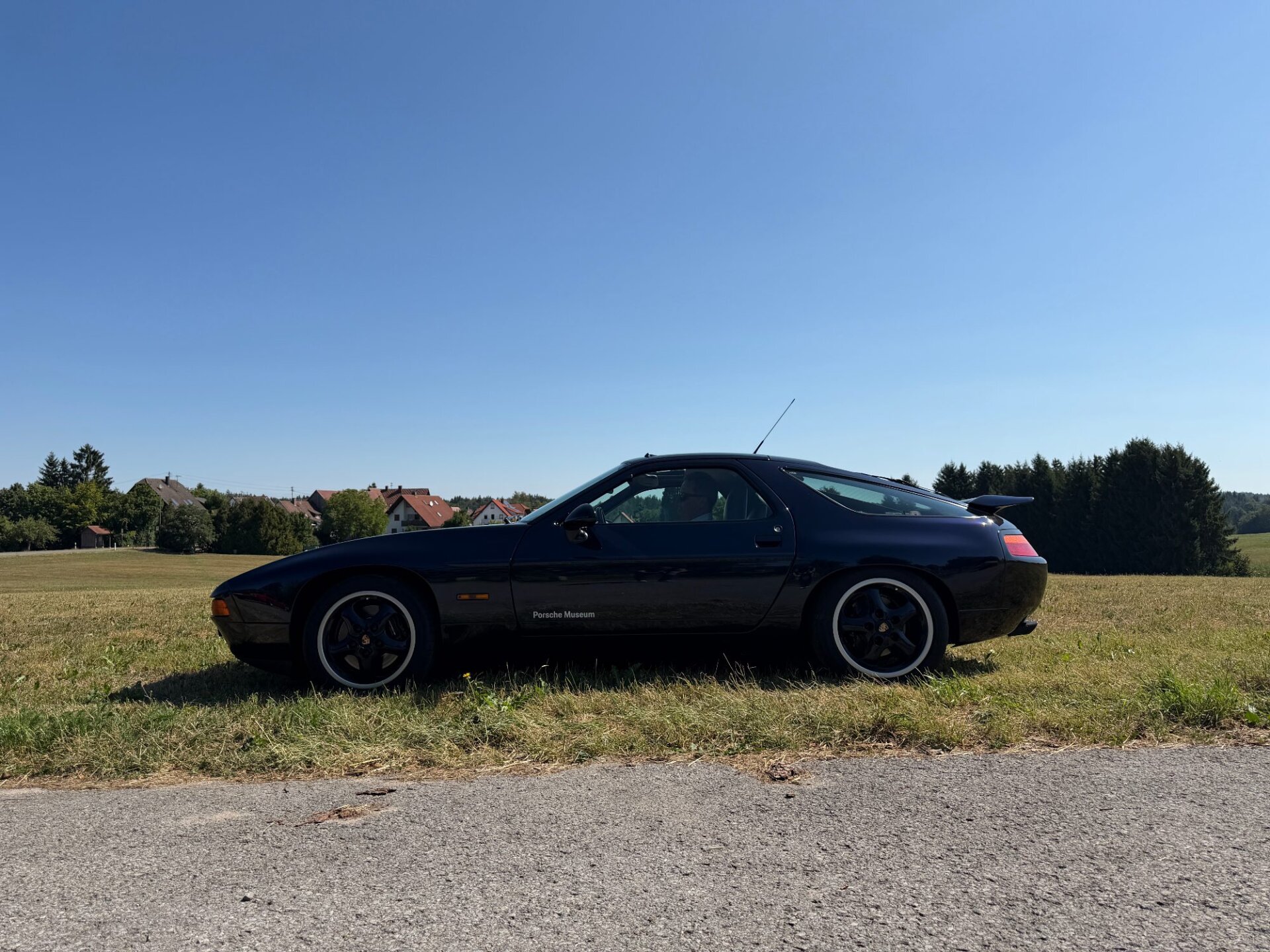 Dunkler Porsche 928 auf einer Wiese