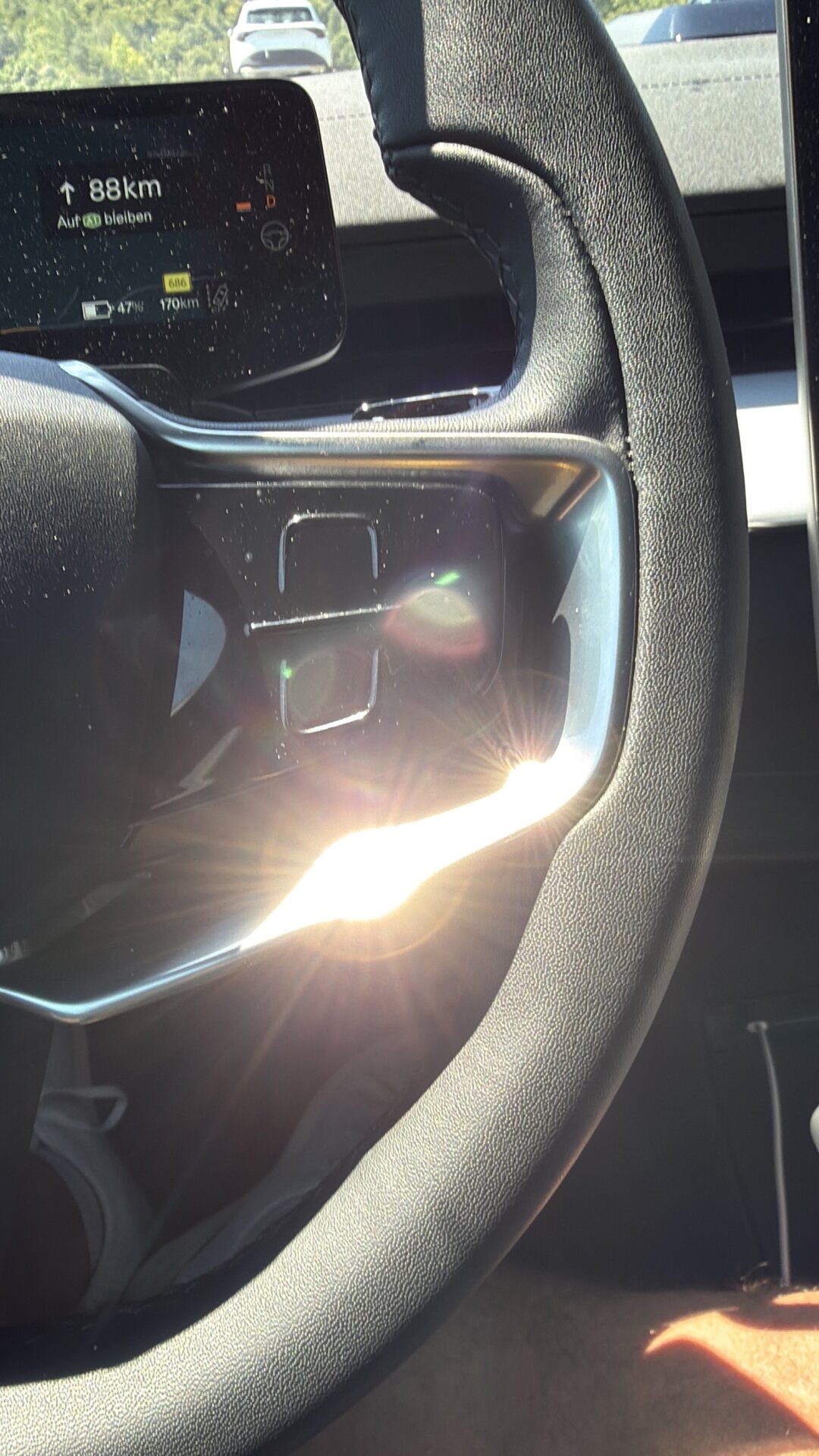Polestar 3: tiefstehende Sonne spiegelt sich blendend in der Chromleiste unter dem Lenkrad-Airbag