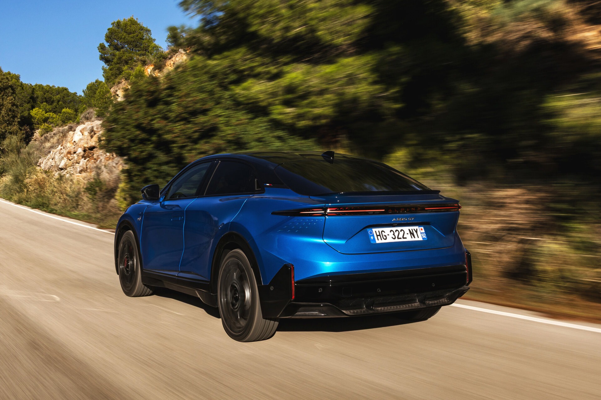 Alpine A390 GT von hinten in rasanter Fahrt auf einer Landstraße