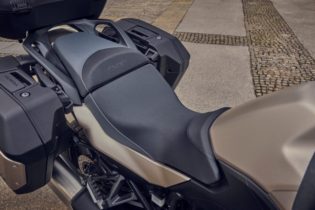 Detailaufnahme der grauen Sitzbank und des Heckbereichs einer Honda NT1100 mit montierten Seitenkoffern und Topcase, fotografiert aus der Vogelperspektive auf gepflastertem Untergrund.
