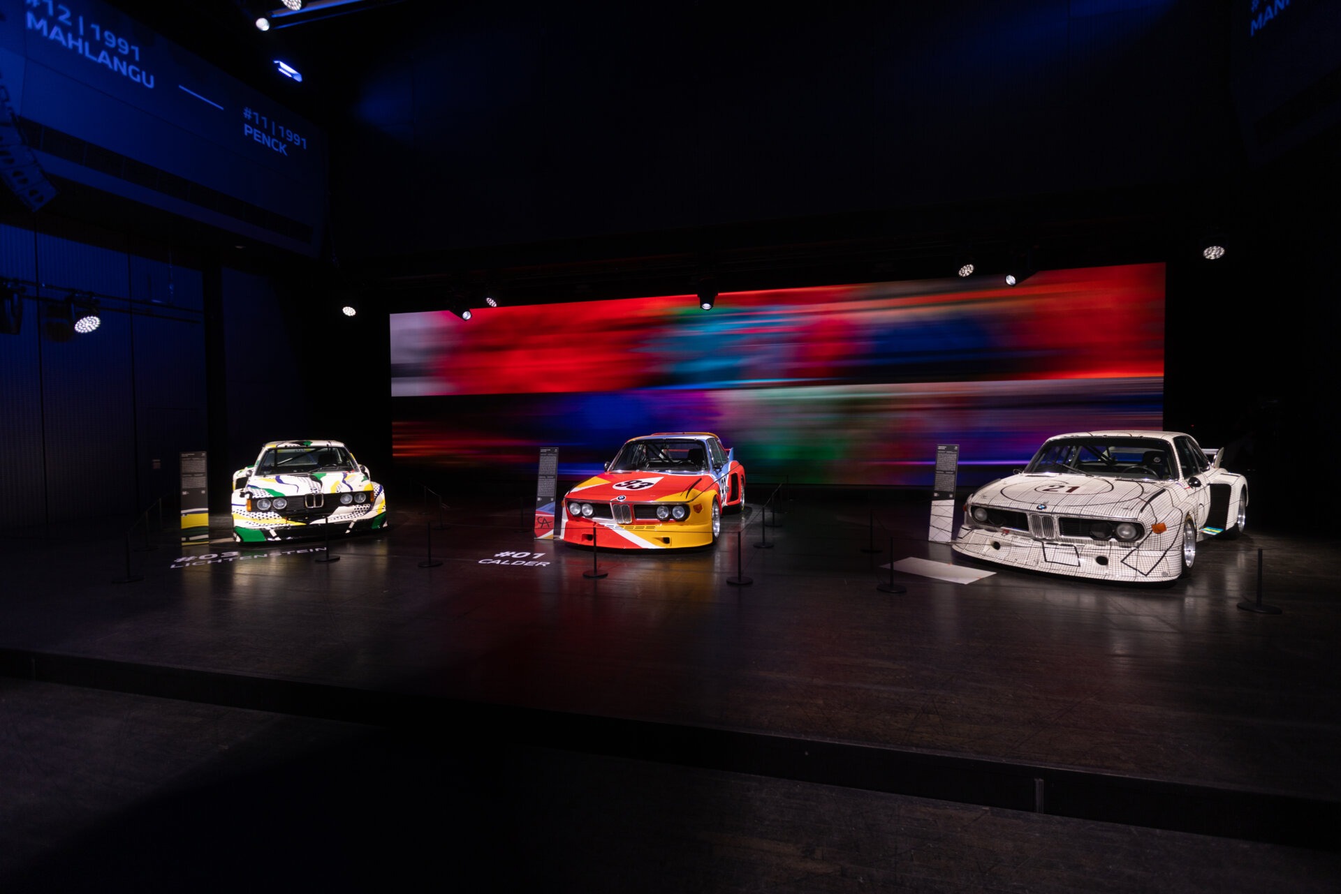 BMW Art Car 3 von Roy Lichtenstein, BMW Art Car 1 von Alexander Calder und BMW Art Car 2 von Frank Stella in der Ausstellung BMW Welt München