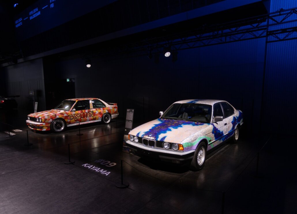 BMW Art Car 7 von Michael Nelson Jagamara und BMW Art Car 9 von Matazo Kayama in der Ausstellung BMW Welt München