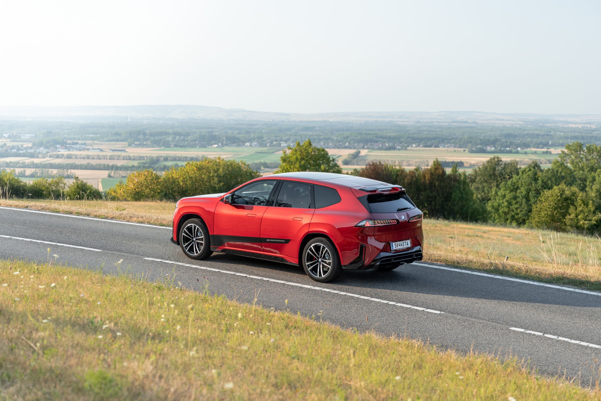 BMW iX3 40 in der Heckansicht auf einer Höhenstraße mit Blick über das Wiener Becken