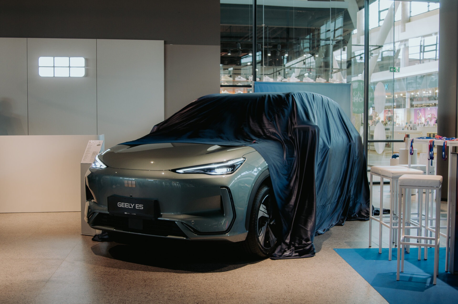 Teilverhüllter Geely E5 im Ausstellungsraum