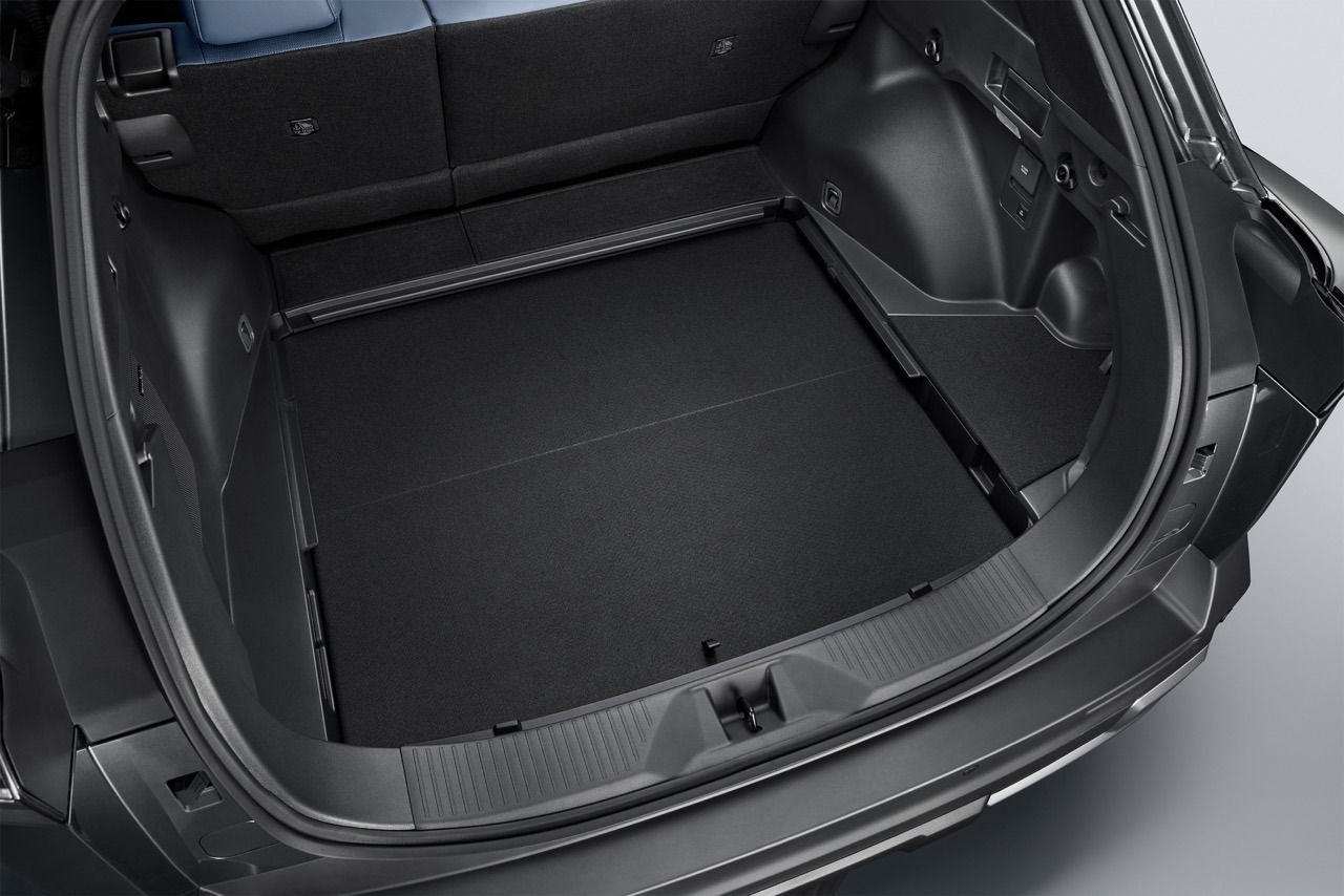 Blick in den schwarzen Kofferraum eines SUV mit umgeklappter Rücksitzlehne aus erhöhter Heckperspektive vor neutralem Hintergrund.