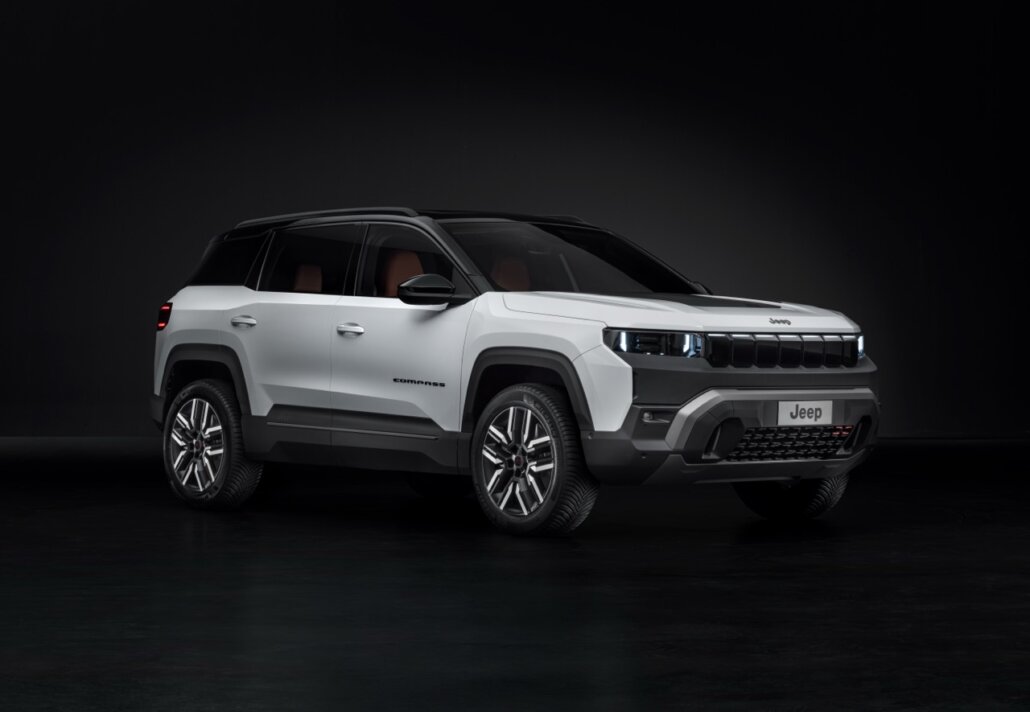 Dreiviertelansicht vorne rechts eines weißen Jeep Compass SUVs mit schwarzem Dach vor dunklem Hintergrund.