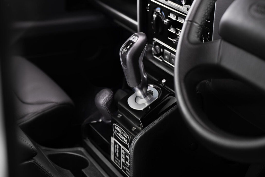 Innenraum-Detail des Land Rover Defender Classic Works V8: Schalthebel und Getriebetunnel der ZF-Achtstufenautomatik
