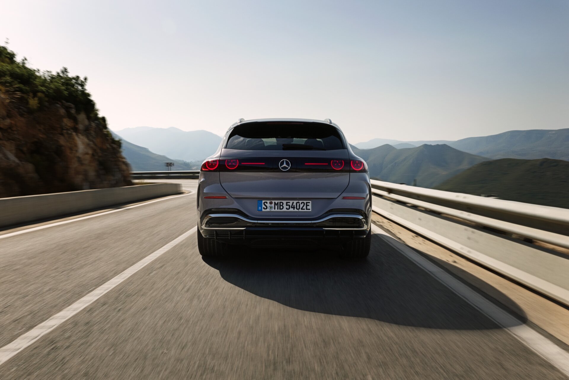 Mercedes GLC 400 4MATIC elektrisch in Heckansicht auf einer kurvigen Küstenstraße mit Bergpanorama