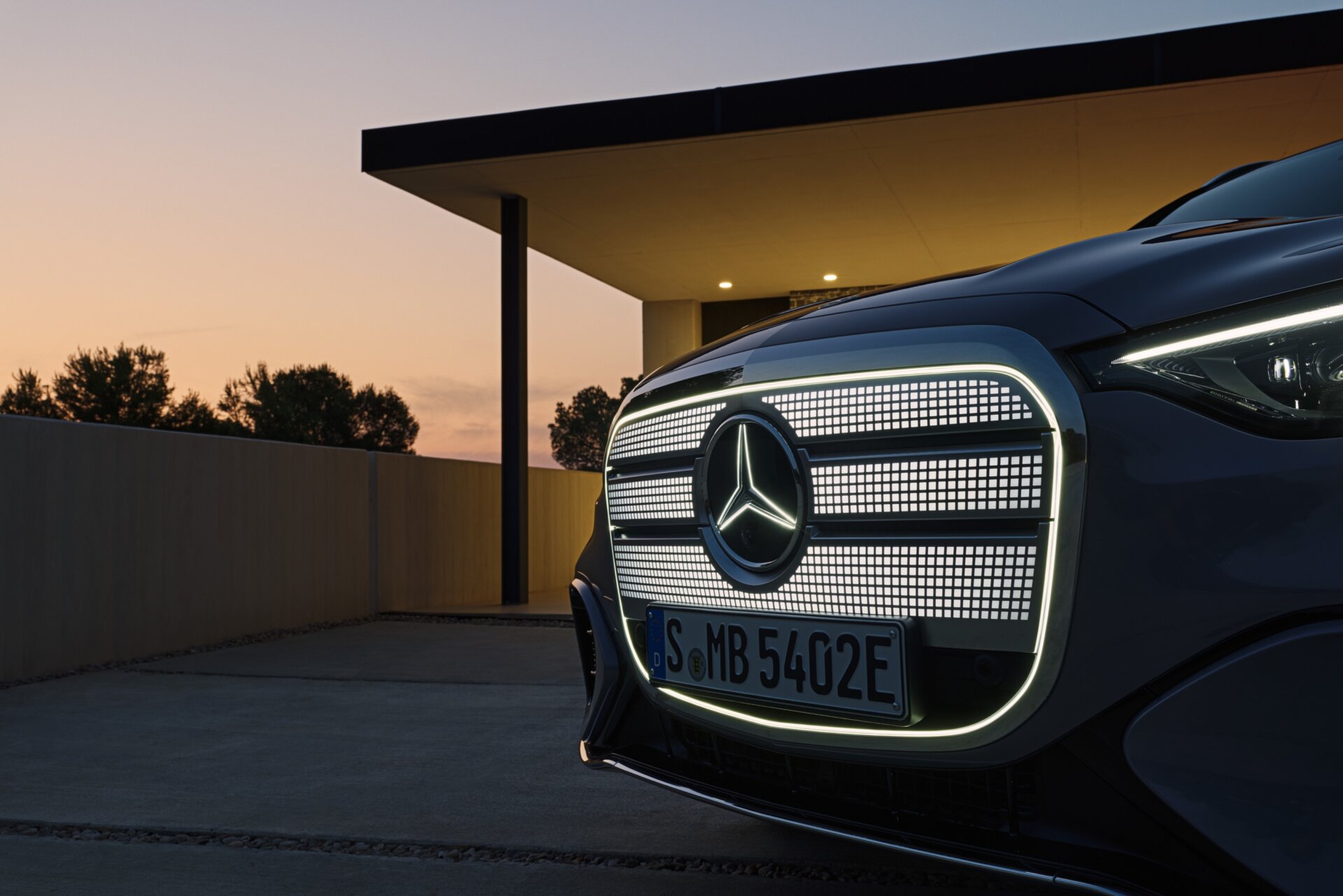 Beleuchteter Kühlergrill an der Frontpartie des Mercedes-Benz GLC elektrisch in der Dämmerung