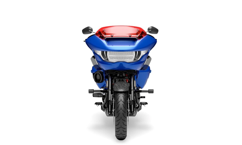Zu sehen ist die Frontansicht eines blauen Harley-Davidson-Touring-Motorrads mit roter Verkleidungsscheibe vor weißem Studiohintergrund.
