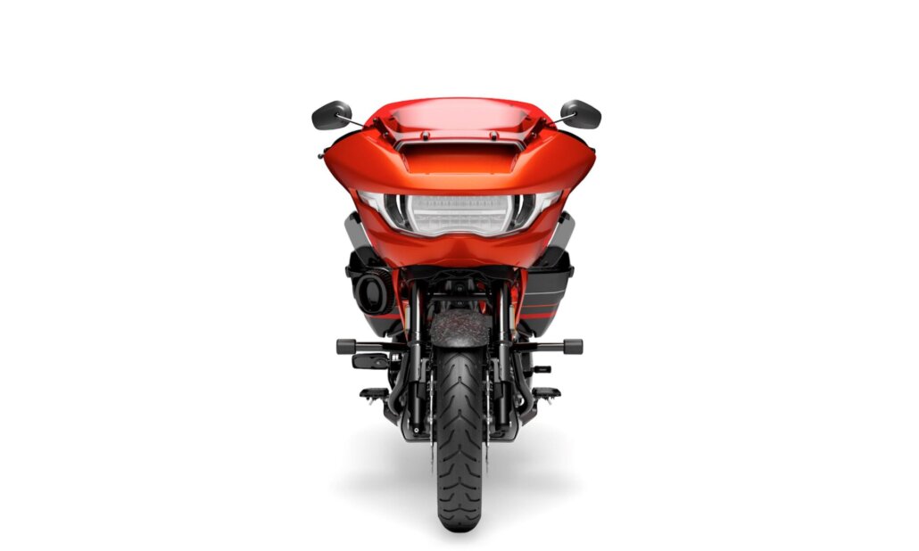 Zu sehen ist die direkte Frontansicht eines orange-roten Harley-Davidson-Touring-Motorrads vor einem neutralen, weißen Studiohintergrund.