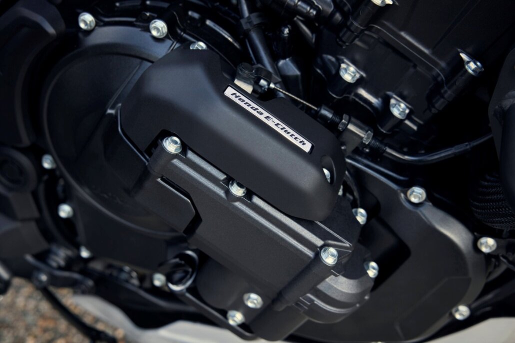 Detailaufnahme des schwarzen Motorblocks mit sichtbarem Honda E-Clutch-Schriftzug in einer Studio- oder Werkstattumgebung.