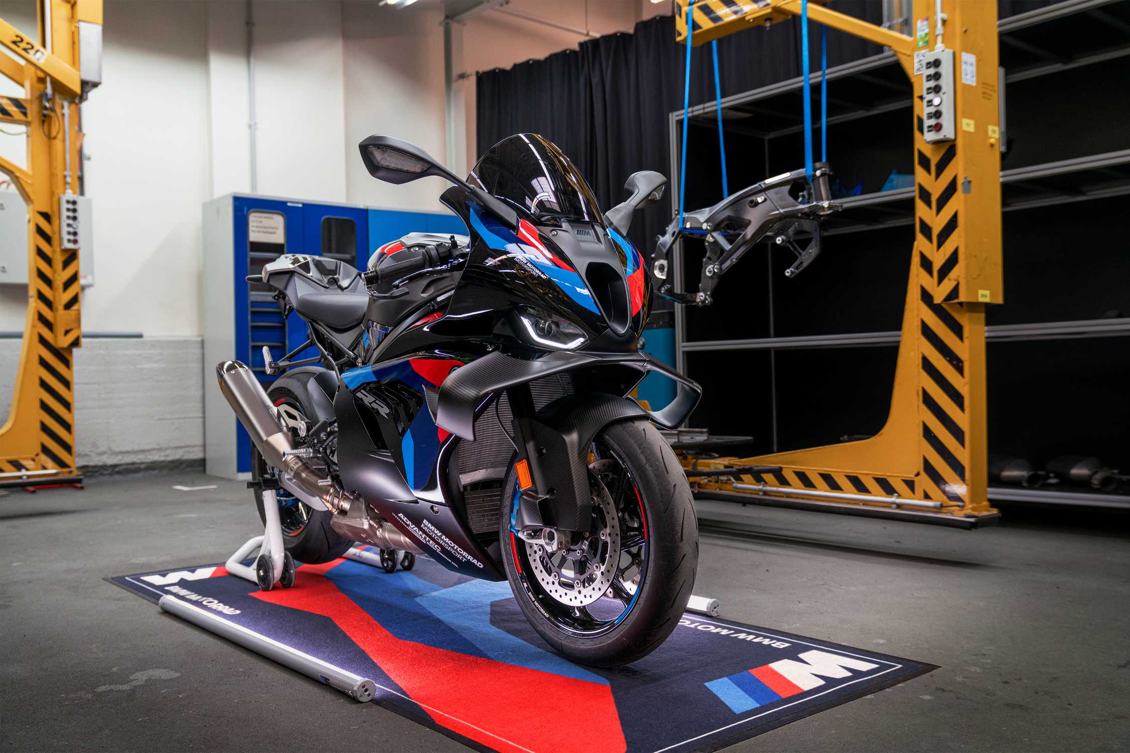 BMW M 1000 RR in der Werkstatt neben dem aufgehängten M Motorsport Rahmen