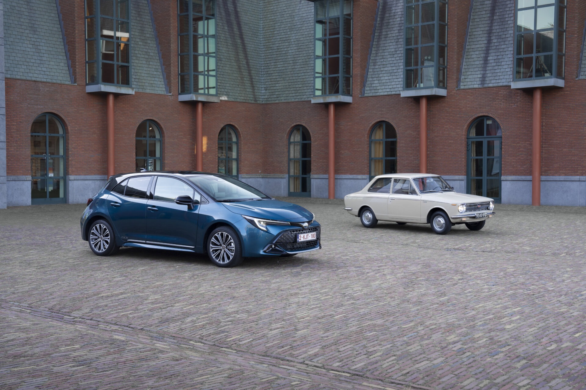 Toyota Corolla Hatchback in Blau neben einem historischen Corolla