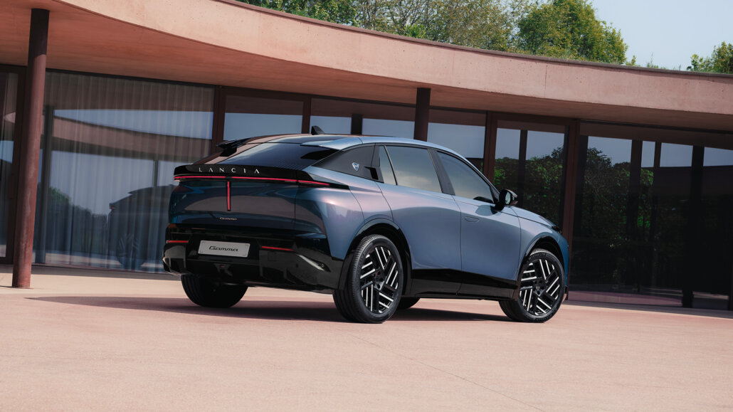 Lancia Gamma Crossover-Coupé in Dreiviertelansicht hinten rechts vor einem Gebäude mit großer Glasfront